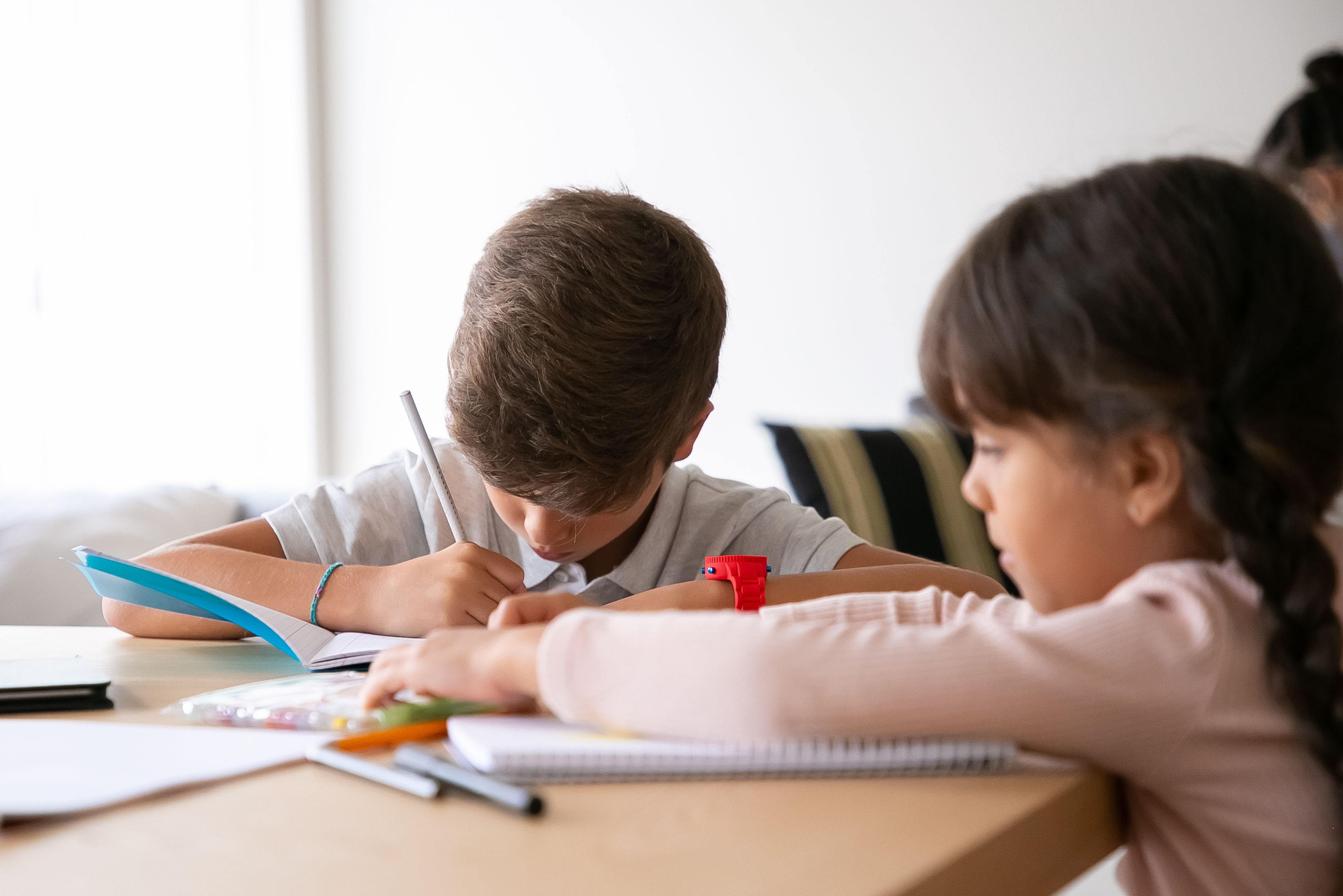 Children completing schoolwork together at a table
